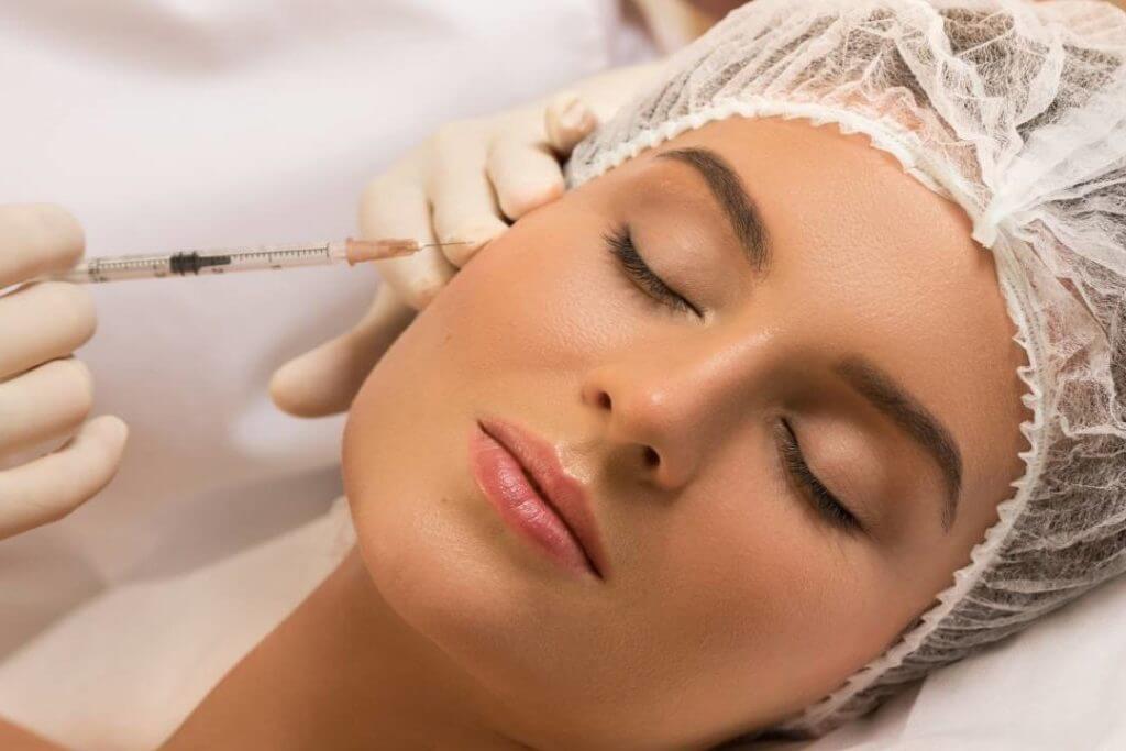 Cosmetologist makes Botox rejuvenating anti wrinkle injections on the face of a beautiful woman. Female aesthetic cosmetology in a beauty salon | Enchanted Medical Aesthetics in Ormond Beach, FL